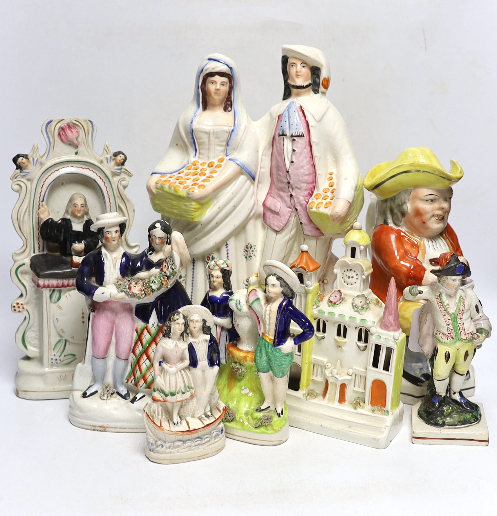 Seven 19th century Staffordshire figure groups including Orange Sellers and Wesley, together with a Toby jug, 35cm high
